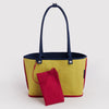 The reverse side of the navy nylon tote back featuring a bright yellow body and a small flat red interior pouch attached by a leash. 