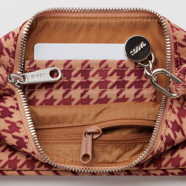 An interior view of a houndstooth bag with card slots and a zip pocket.