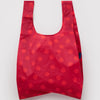 A nylon shopping bag in red with lighter red polka dots against a white backdrop.
