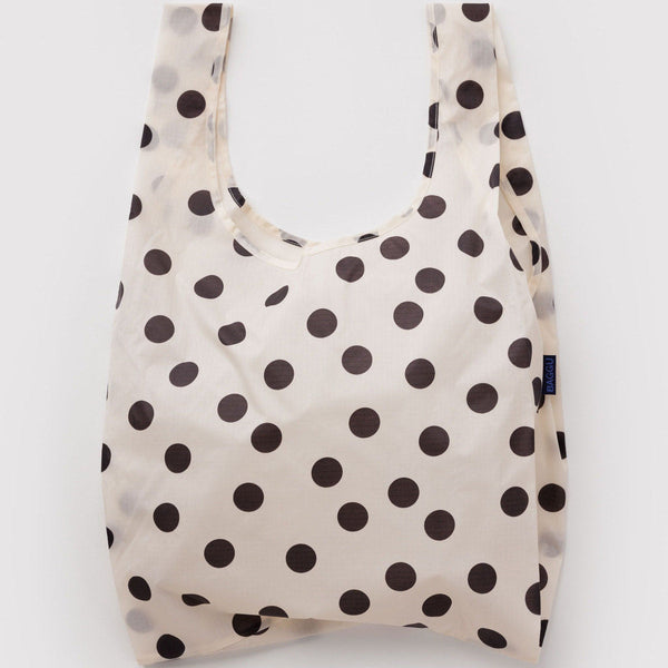 A nylon shopping bag in off-white with black polka dots against a white backdrop.