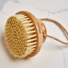Bamboo body brush with natural bristles on a light background