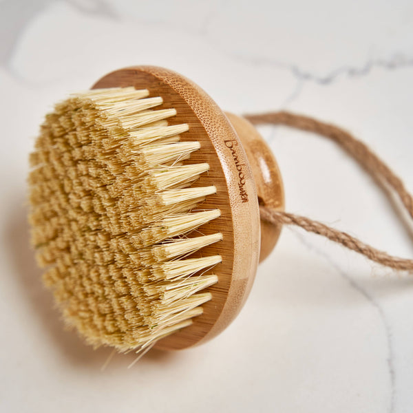 Bamboo body brush with natural bristles on a light background