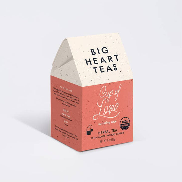 A box of Big Heart Tea Cup of Love tea bags with a pink and white color scheme and text detailing the product.