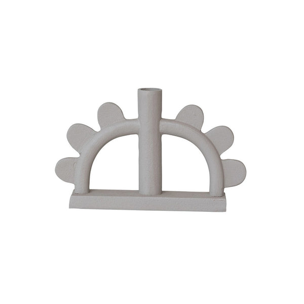 A minimalist, sculptural candle holder made of matte, textured aluminum in a light beige-white color, featuring a central vertical cylinder and five scalloped protrusions on either side, set against a plain white background.