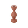 A rust orange aluminum taper candle holder in a textured zig-zag shape against a white background. 