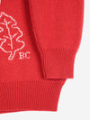 A close-up detail of a sleeve and hem of a red and white sweater with the brand initials 'BC'.