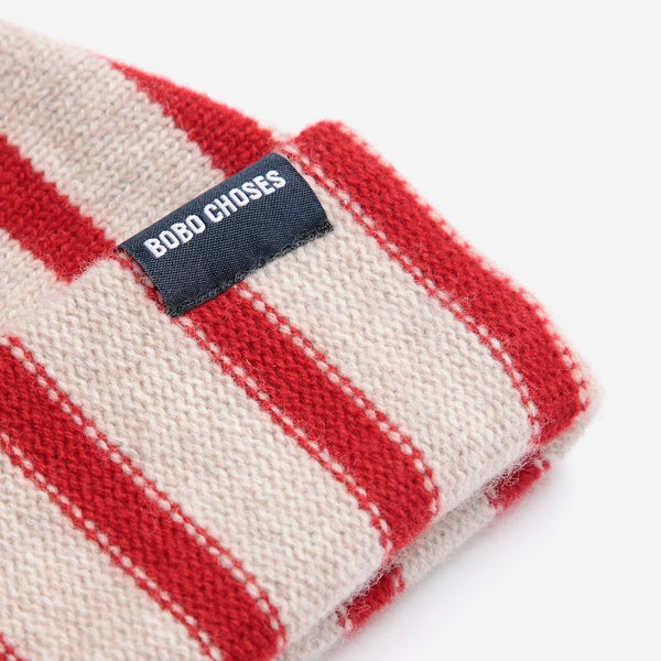 A close-up view of a red and white striped wool beanie hat with a small black 'Bobo Choses' label against a white background.
