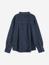 A back view of a dark wash denim shirt with a subtle floral print against a white background.