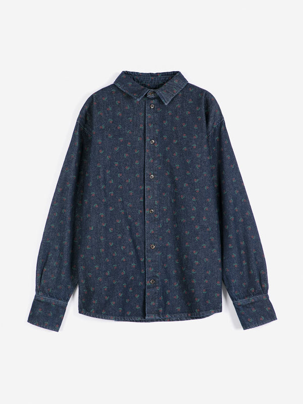 A dark wash denim collared shirt with a subtle floral print against white background.