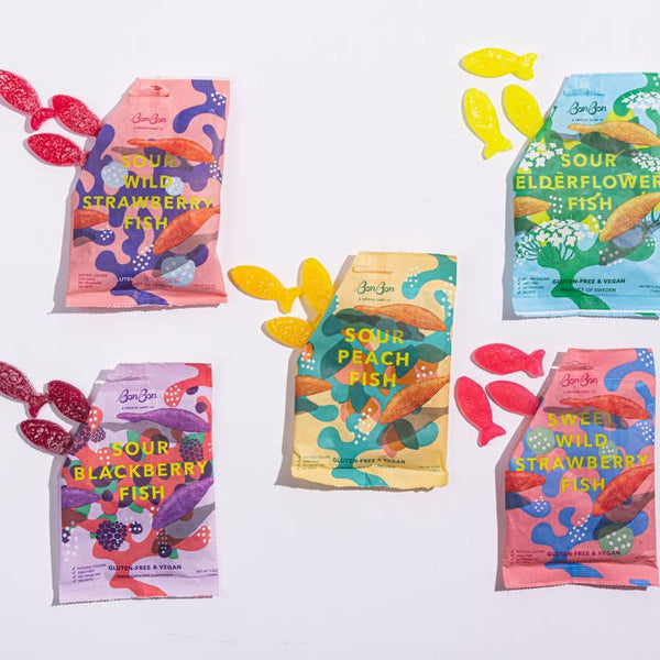 A collection of Swedish Fish candy packets in various flavors, including Sour Blackberry, Sour Peach, Wild Strawberry, and Sour Elderflower. The packets feature colorful designs with illustrations of fish.