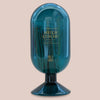 Blue glass match cloche with brand name on a beige background
