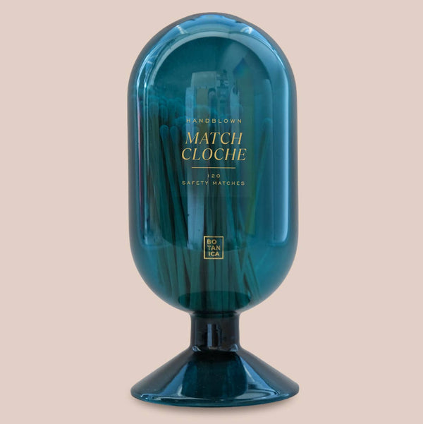 Blue glass match cloche with brand name on a beige background