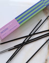 Incense sticks with a box labeled 'Matcha + Coconut Milk' on a marble surface