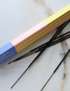 A close up view of a box of incense and sticks against a marble surface. 
