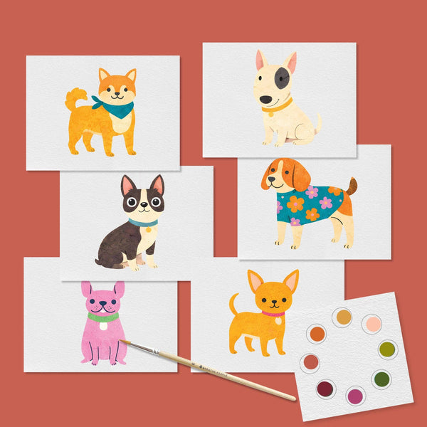 Set of postcards with watercolor illustrations of dogs along with a paintbrush and dry dot watercolor palette against a rust red background.