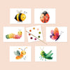 Set of six watercolor illustrated postcards of various garden critters along with a paintbrush and dry dot watercolor palette against a cream background.