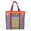 Multicolored woven tote bag with blue, maroon, and orange accents and an olive side pocket on a white background