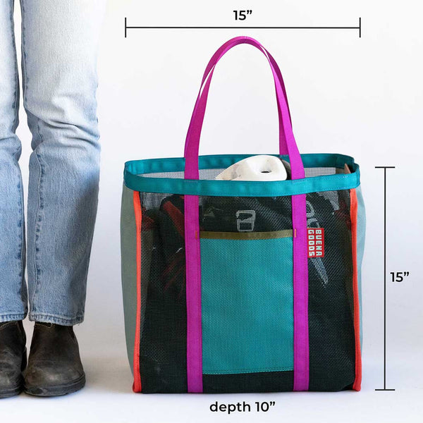Multicolored tote bag with dimensions shown next to a person wearing jeans and boots.