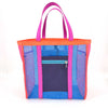 Multicolored mesh tote bag with pink handles and a navy zip-top side pocket on a white background