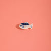 Small navy and iridescent white dashi fish hair claw on a pink background