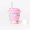 Pink unicorn print reusable cup with pink silicone wavy grip, lid, and straw against a white background.