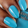 Hand with robin's egg blue nails holding a bottle of Cirque Colors nail polish.