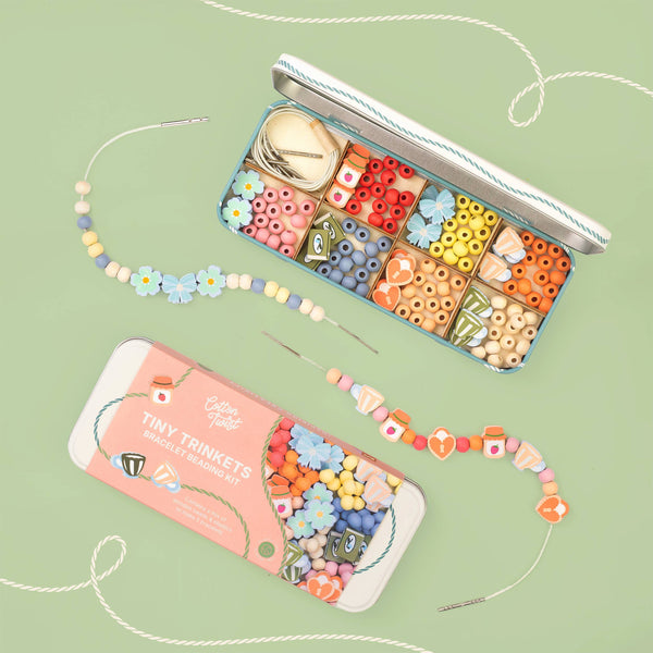 Colorful bead kit with beads and tools on a green background