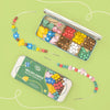 Wildflower bracelet making kit with beads and tools on a green background
