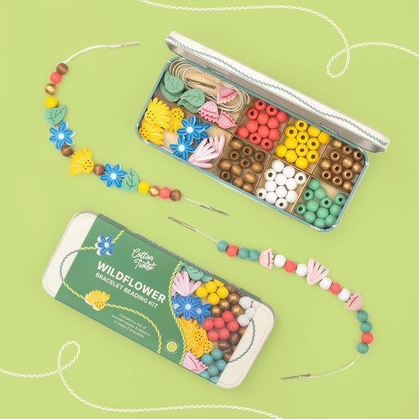 Wildflower bracelet making kit with beads and tools on a green background