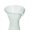 A close-up view of the top spout of a bubble glass decanter against a white background. 