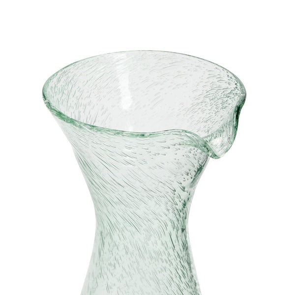 A close-up view of the top spout of a bubble glass decanter against a white background. 