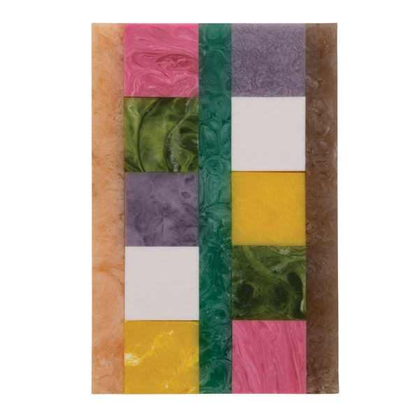A vibrantly colored marbled resin serving board in a multicolor block pattern against a white background.