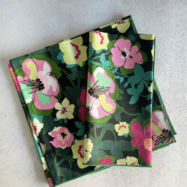 Stack of floral-patterned cloth napkins stacked on a light gray surface