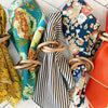 Set of colorful napkins tied with wooden rings on a light wooden surface