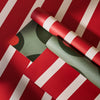 Two rolls of red and green striped paper on a red background with white stripes.
