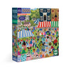 Jigsaw puzzle box with colorful artwork of a country fair scene on a white background