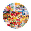 Round jigsaw puzzle with colorful illustrations of food, flowers, and a bottle of Agua.