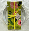Floral patterned napkin with a yellow ribbon on a white plate