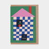 Greeting card with a checkered house design on a white background