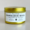 Gold candle tin with a Mandarin Basil label on a light background