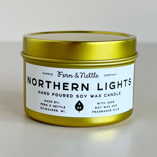 Gold candle tin with 'Northern Lights' label on a light background