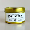 Gold candle jar with 'Paloma' label on a light gray background