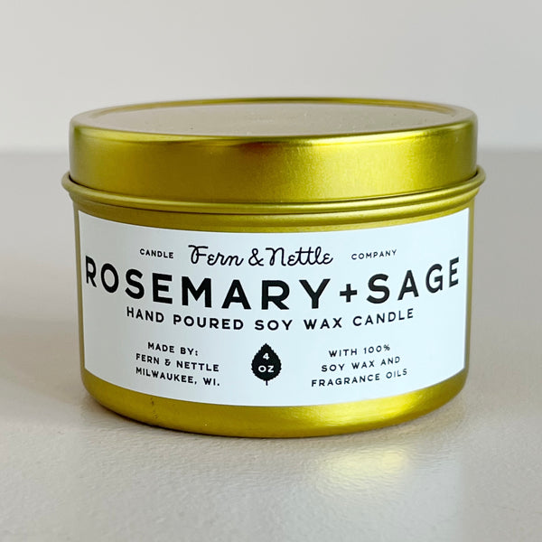 Rosemary + Sage candle in a gold tin with a white label on a light background