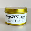 Gold candle jar with 'Tomato Leaf' label on a light background