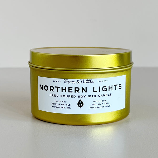 Gold candle jar with 'Northern Lights' label on a light gray background