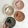 Four woven baskets with yarn on a light background.