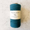 Peacock blue-green cotton rope spool with 'Flax & Twine' branding on a white marble surface.
