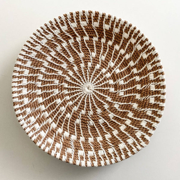 Woven basket with brown and white pattern on a light gray background