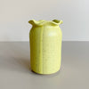 Speckled yellow ceramic vase on a neutral background