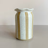White speckled ceramic vase with vertical natural brown stripes on a plain background
